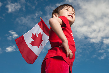 Chica joven que sostiene la bandera canadiense en el Día de Canadá.