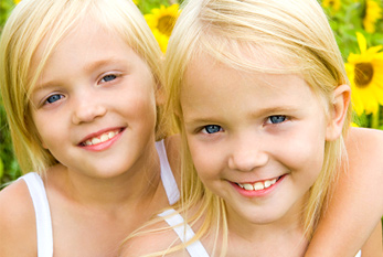 Dos hermanas en frente de un campo de girasol.