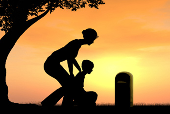 Viuda con su hijo sobre la tumba de su marido.
