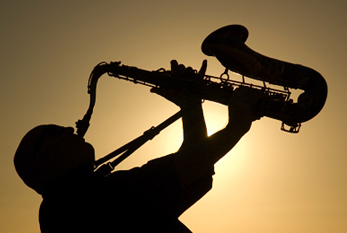 La silueta de un saxofonista con el sol en el fondo.