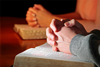 Dos mujeres rezando junto con sus biblias santas.