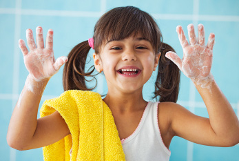 Una chica de risa con el jabón en sus manos.