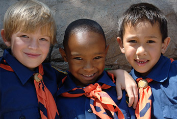 Tres muchachos en un uniforme de explorador.