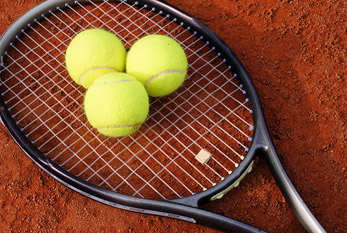 Tres bolas en la raqueta de tenis.