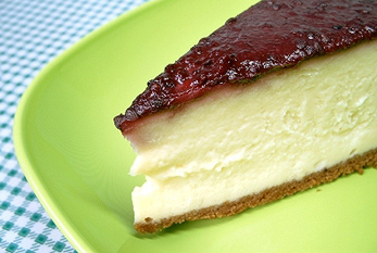 Una rebanada de pastel de queso de frambuesa en una placa verde.